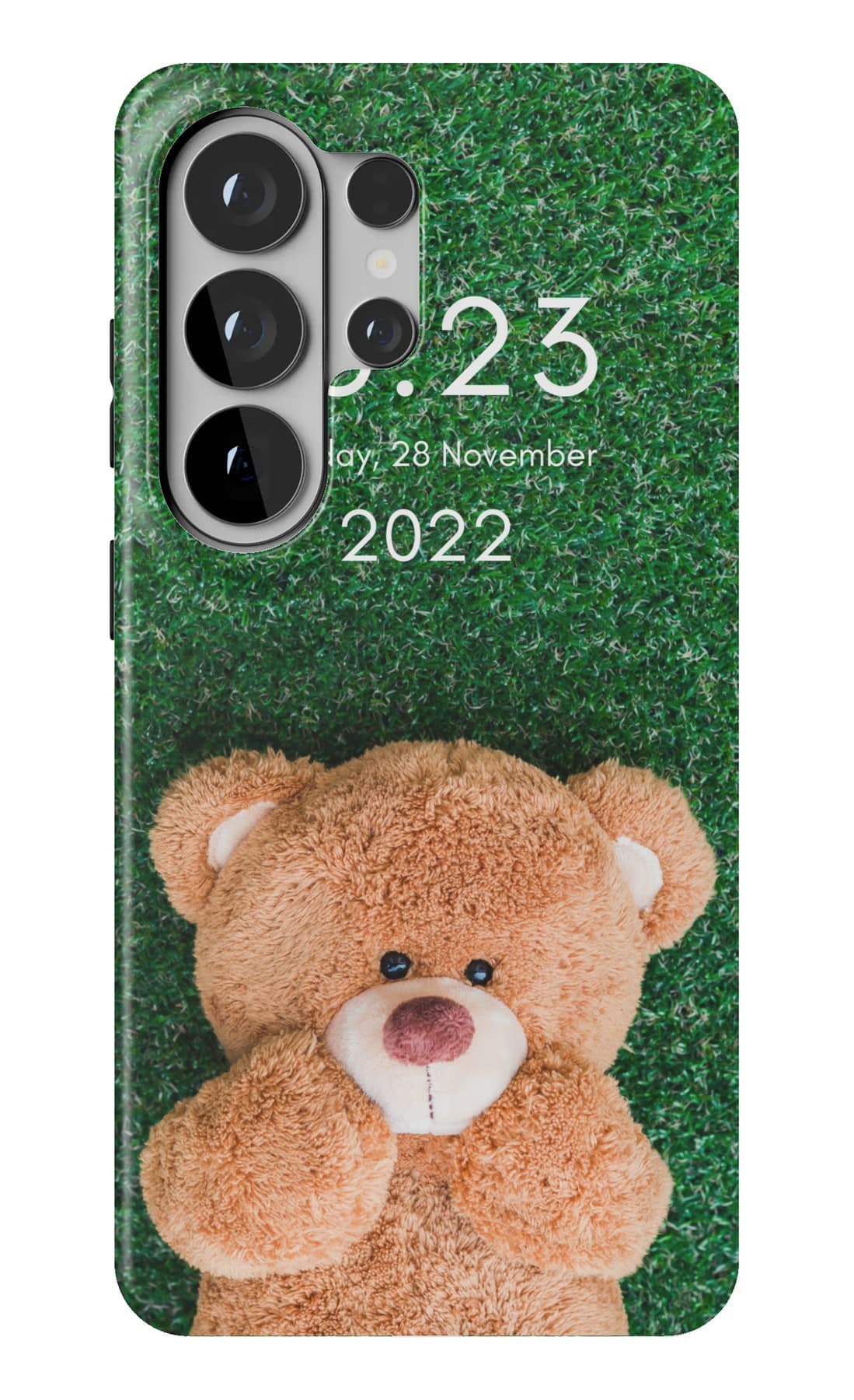 A teddy lying in bright grass. Shown on a Galaxy.