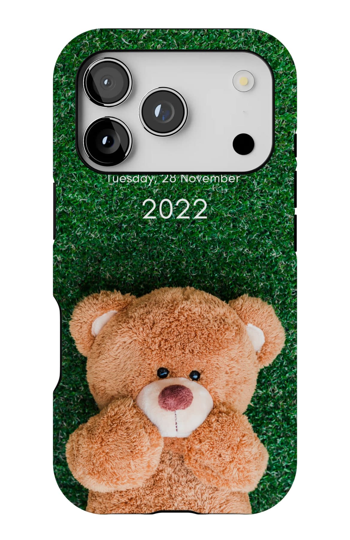 A teddy lying in bright grass. Shown on an iPhone.